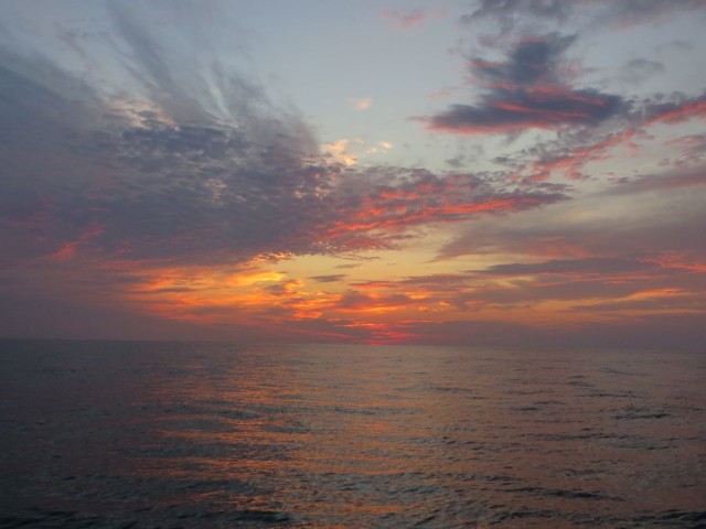 Dawn brightens in the sky over the ocean
