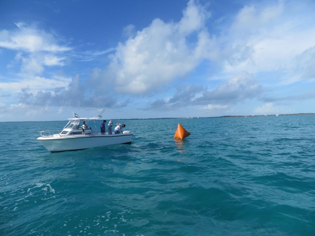 The "marker boat" drops one of the orange markers.