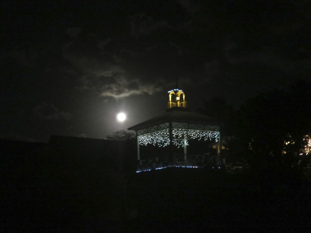 The full moon shines behind this gazebo