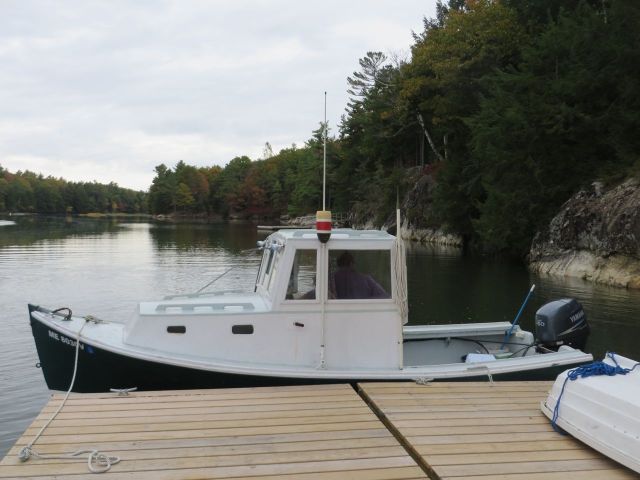 The lobster boat with its buoy colors displayed on the cabin top.