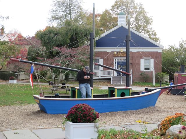 Tim takes a moment to text while standing in the model sailboat.