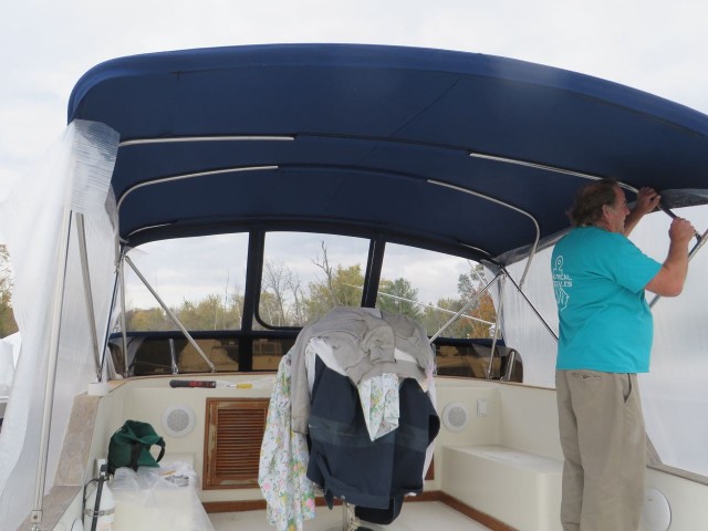 Tempting the bimini with large sheets of plastic to make a the pattern. Very precise work, or at least it should be!