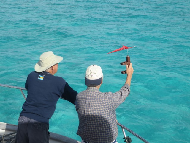 David and John are checking the wind in order to place the start line and the windward mark.