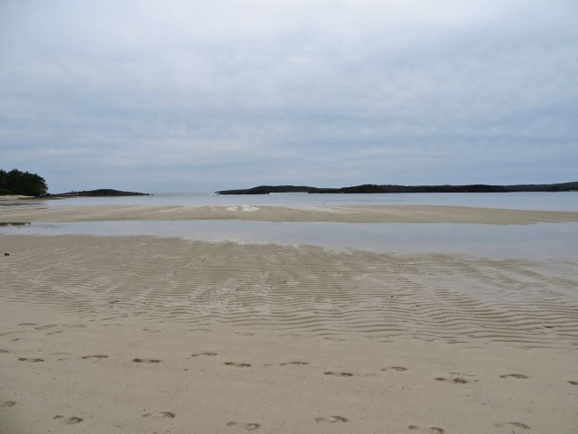 Footprints and ripples in the sand at a very low tide on this slightly cloudy morning.