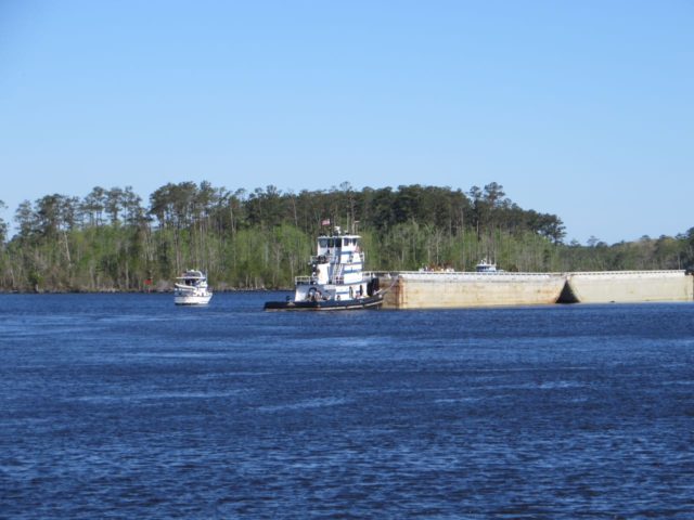 "Time to Go", the trawler traveling ahead of us, rounds past a tug and barge that is off to the side of the ICW. This one was Aries, a tug-barge combo we would get to know rather well over the next few hours.