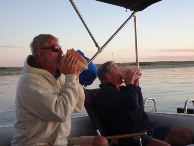 Al and Dean blow their conch horns for the sun's beautiful performance. 